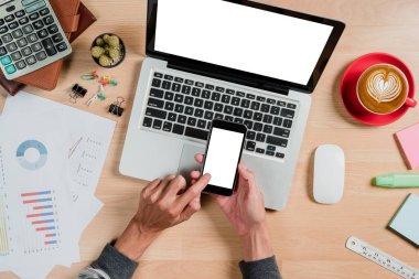 Adam elleri boş ekranı tutuyor. Çalışma masasında bir akıllı telefon. Ürün gösterimi için boş ekran..