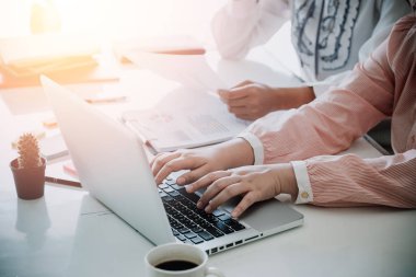 İki meslektaş masadaki yeni modern bilgisayar laptopuyla verileri tartışıyor. İş ekibi analizi ve strateji kavramını kapat.