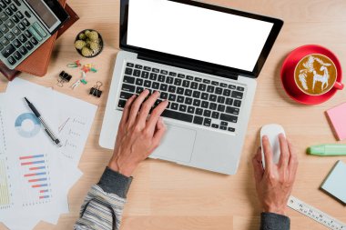 Ofiste boş ekran dizüstü bilgisayar ve çalışma alanı üzerinde çalışan bir adam. Ürün gösterimi için boş ekranlı üst görünüm.