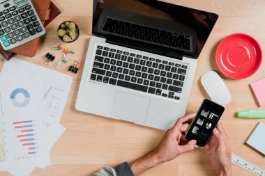 Akıllı telefon ve bilgisayardaki finansal verileri analiz eden bir işadamı. Üst görünüm