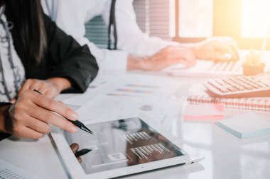 Toplantıda touchpad tableti ve laptop kullanan iki genç iş adamı. İş ve strateji kavramı..