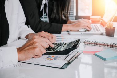 Finansal veri ile çalışmak için hesap makinesi ve dizüstü bilgisayar kullanan iş ekibi. Kapatın. İş analizi ve strateji kavramı.