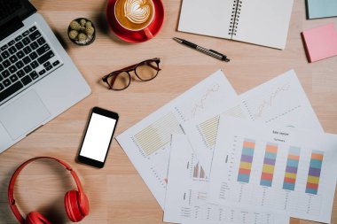 Bilgisayarlı masa masası, iş belgeleri, kalem, bardaklar, akıllı telefon, kahve ve diğer malzemeler.