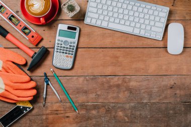 Bilgisayarlı ofis masası, bir fincan kahve ve mühendis teçhizatı. Fotokopi alanı olan üst görünüm. Arkaplan inşa projesi fikri.