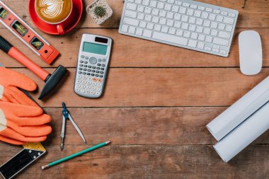 Bilgisayarlı ofis masası, bir fincan kahve ve mühendis teçhizatı. Fotokopi alanı olan üst görünüm. Arkaplan inşa projesi fikri.