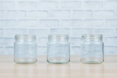 Ahşap masada üç cam kavanoz..