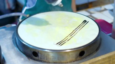 Şef sütlü krepe çikolata dolduruyor. Tayland sokak yemekleri..