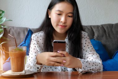 Genç ve güzel kadın cep telefonunda arkadaşları ile sohbet.