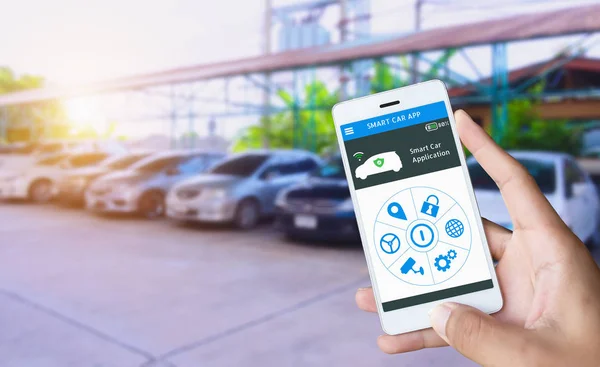 Otomatik otopark ve akıllı bana uygulama, otomatik sürücü fonksiyon ve akıllı araç konsepti şeylerin Internet almak. El tutma akıllı telefon ve uygulama kontrol paneli ile Araba Park arka plan bulanıklık.