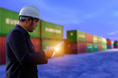 Mühendis tabet ile konteyner arka plan üzerinde çalışıyor. Konteyner arka plan üzerinde inşaat müdürü.