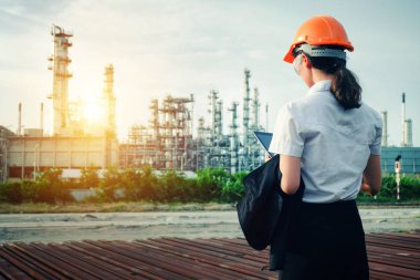 Mühendis büyük bir endüstri arka planında duruyor. Sektörün arka planında inşaat yöneticisi.