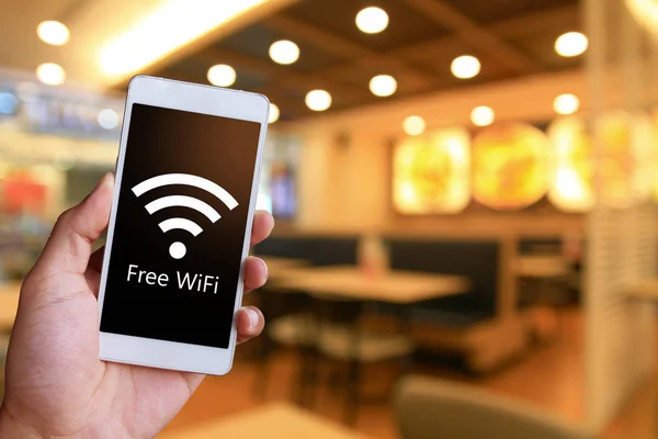 Adam beyaz bir genel smartphone ücretsiz Wi-Fi gösterilen tutuyor. Kamu erişim noktasına bağlanma.