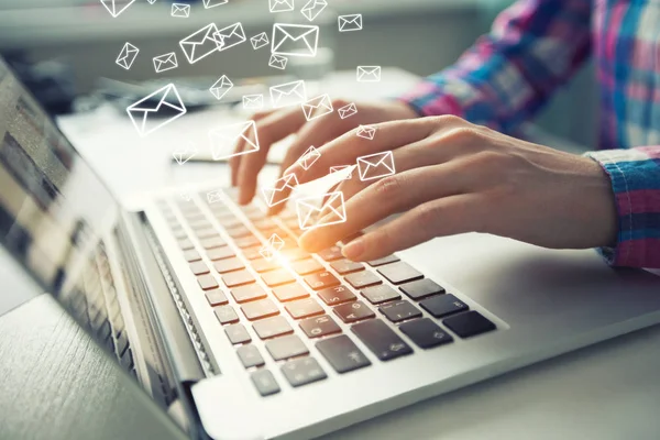 İş adamı çalışma alanı dizüstü bilgisayar ile e-postaları gönderiyor.