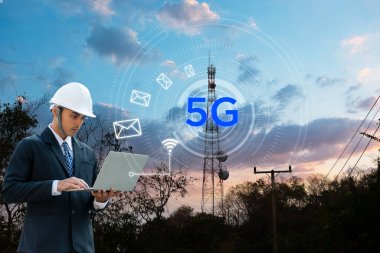 Ağ mühendisi, anten kulesinin yanındaki 5G şebekesinde dizüstü bilgisayar üzerinde çalışıyor. İş adamı e-postayı gönderiyor. Mühendis kablosuz ağı test ediyor..