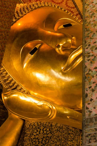Face of the Golden Reclining Buddha Statue of Wat Pho Monastery in Bangkok of Thailand.