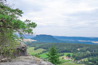 Birçok ağacın yetiştiği dağın tepesinden vadi manzarası ve bunların arasında Avrupa 'da bir yerde küçük bir köy var.