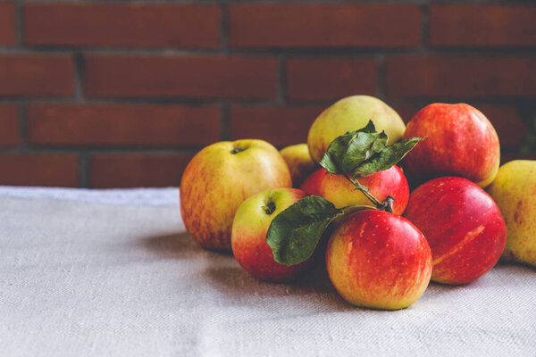 На столе лежат летние жареные, спелые и сочные яблоки