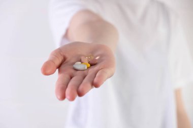 Uzamış avuç içleri farklı haplar gösteriyor.