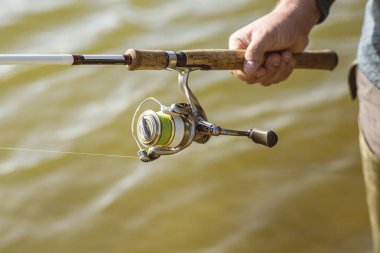 Çizmeli bir adam gölde durup iplikle balık tutuyor. Han