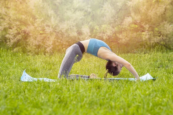 Ung vit kvinna som yogar i parken. — Stockfoto