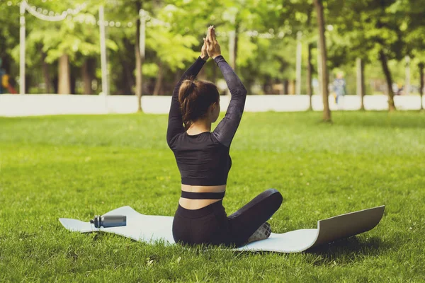 Beyaz bir kadın parkta yoga yapıyor..