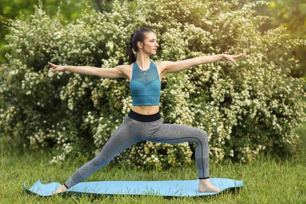 Beyaz bir kadın parkta yoga yapıyor..