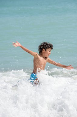 Sert sularda sahilde bir yaz tatili oynayan mutlu çocuk