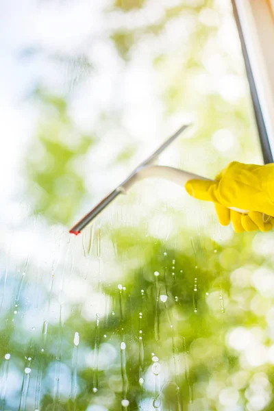 手清洁玻璃窗格与洗涤剂和橡胶铝雨刷 用亮黄色手套的女性手洗窗户 — 图库照片