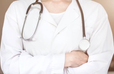 bir doktor bir stetoskop ile Beyaz paltolu kollarını göğsüne üzerinde çarpı işareti ile duruyor. yakın çekim