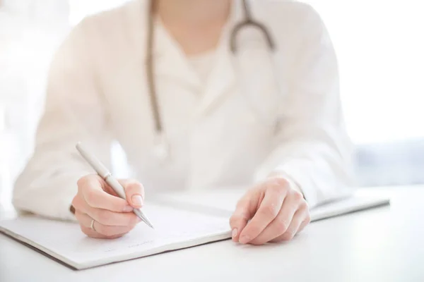 Médico Vestido Vestir Com Estetoscópio Senta Uma Mesa Escreve — Fotografia de Stock