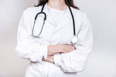 Gözlük ve bir steteskop ve kolları ile tıbbi beyaz önlük giyen genç esmer doktor kadın portresi beyaz bir arka plan üzerinde çarpı işareti