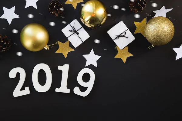 Happy New Years layout. numbers 2019 notepad and free space for text. Christmas decorations, Christmas toys, gold stars. Goals for the new year. mock up on black backround