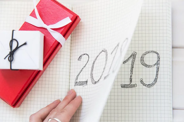 Mano da vuelta el calendario 2018 - 2019. Planes y metas para el nuevo año. Regalos de Navidad — Foto de Stock