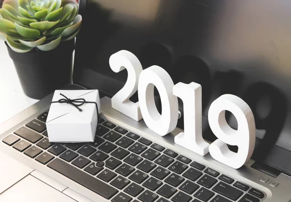 Diseño de Año Nuevo en la oficina. 2019. Decoraciones navideñas, juguetes navideños, conos, cajas con regalos y laptop . — Foto de Stock