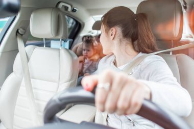 Çocuk ileri arabadan oturan oturan anne yakın bir emanet koltukta. Çocuk oto koltuğu bebek. çocukların güvenli ulaşım. Aile seyahatleri