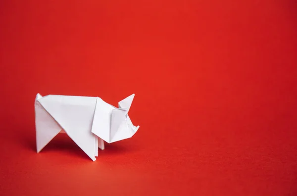 Çince Zodyak işareti domuz yılı. yeşil origami kağıt ağaç ve 2019, kırmızı bir arka plan üzerinde beyaz domuz sembolü boş alan için metin, Minimalizm. Mutlu yeni yıl 2019 yıl