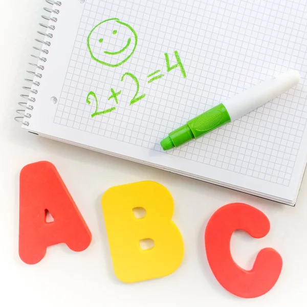 Educação na escola primária. um layout de letras ABC, um caderno e marcadores em um fundo branco. O início do ano letivo. Espaço livre para texto — Fotografia de Stock