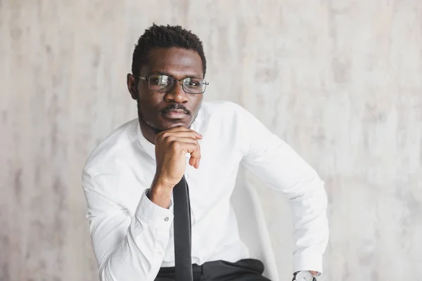 Ελκυστική αφρικανική αμερικανική άνθρωπος σε ένα επαγγελματικό κοστούμι σε ένα κομψό εσωτερικό. επιχειρηματίας και εταιρεία ηγέτης, afroamerican άνθρωπος brooding, αντικατοπτρίζει — Φωτογραφία Αρχείου