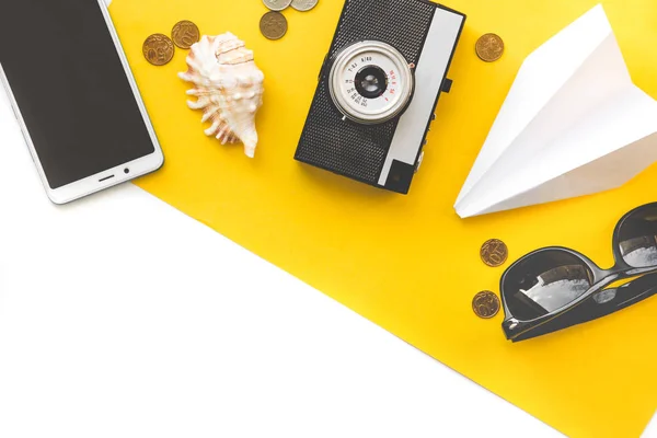 Accessoires de voyage Flatlay sur fond jaune avec espace vide pour le texte. lunettes, avion en papier, vieil appareil photo, coquille et pièces, concept de voyage ou de vacances vue de dessus. Contexte d'été . — Photo