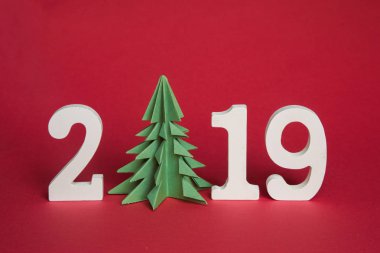 yeşil origami kağıt ağaç ve 2019, kırmızı bir arka plan üzerinde beyaz sembolü boş alan için metin, Minimalizm. Mutlu yeni yıl 2019 yıl
