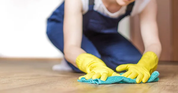 Servicio de limpieza con equipo profesional durante el trabajo. Lavado profesional de cocina, limpieza en seco en sofá, lavado de ventanas y suelos. las mujeres en uniforme, monos y guantes de goma . —  Fotos de Stock