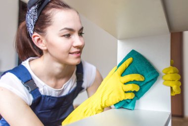 Temizlik hizmeti çalışması sırasında profesyonel ekipman ile. Profesyonel mutfak yıkama, koltuk Kuru Temizleme, pencere ve zemin yıkama. Üniforma, Tulum ve lastik eldiven kadınlarda.