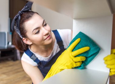 Temizlik hizmeti çalışması sırasında profesyonel ekipman ile. Profesyonel mutfak yıkama, koltuk Kuru Temizleme, pencere ve zemin yıkama. Üniforma, Tulum ve lastik eldiven kadınlarda.