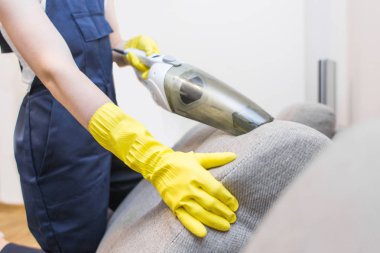Temizlik hizmeti çalışması sırasında profesyonel ekipman ile. Profesyonel Halı Kuru Temizleme, kanepe Kuru Temizleme, pencere ve zemin yıkama. Üniforma, Tulum ve lastik eldiven kadınlarda.