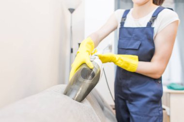 Temizlik hizmeti çalışması sırasında profesyonel ekipman ile. Profesyonel Halı Kuru Temizleme, kanepe Kuru Temizleme, pencere ve zemin yıkama. Üniforma, Tulum ve lastik eldiven kadınlarda.