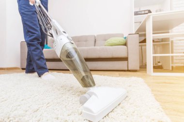 Temizlik hizmeti çalışması sırasında profesyonel ekipman ile. Profesyonel Halı Kuru Temizleme, kanepe Kuru Temizleme, pencere ve zemin yıkama. Üniforma, Tulum ve lastik eldiven kadınlarda.