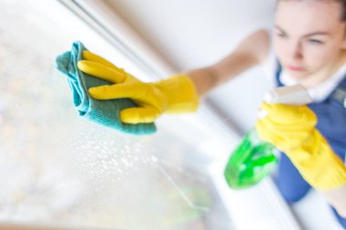 Temizlik hizmeti çalışması sırasında profesyonel ekipman ile. Profesyonel Halı Kuru Temizleme, kanepe Kuru Temizleme, pencere ve zemin yıkama. Üniforma, Tulum ve lastik eldiven kadınlarda.