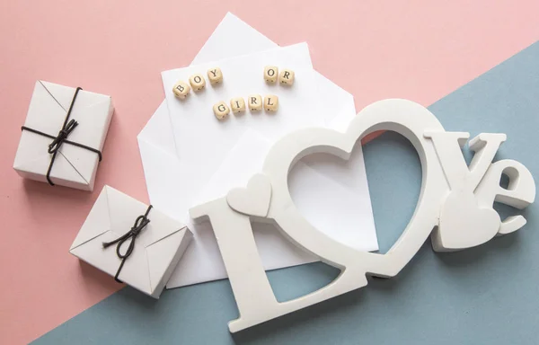 Fiesta de baby shower. La definición de género es una niña o niño. Diseño vista superior en un estilo minimalista sobre un fondo rosa y azul. Zapatos y regalos recién nacidos — Foto de Stock