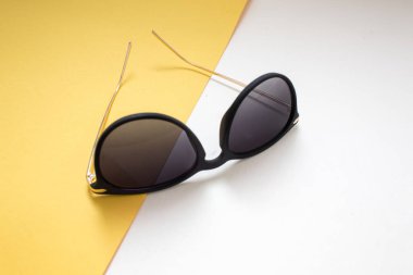 beyaz ve sarı zemin üzerine siyah güneş gözlüğü. minimalizm ve yaz plaj için moda