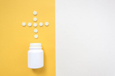 İlaç şişe ve beyaz hap üzerine sarı pastel renkli arka plan döktüm. İlaç ve reçeteli ilaç düz arka plan yattı. Opioid salgın